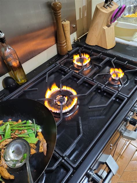 why is my gas stove burning orange instead of blue